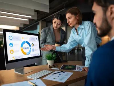 A team analyzing financial data on a computer screen in an office, demonstrating the effectiveness of marketing services for enhancing business strategies and growth.