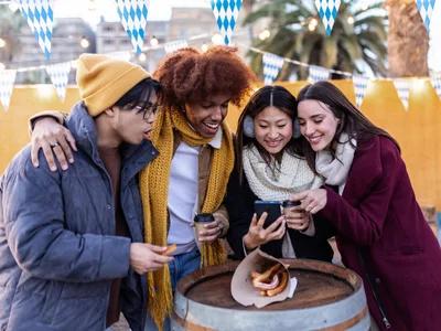 Friends enjoying Social Media Marketing in London event, sharing content and laughs outdoors.