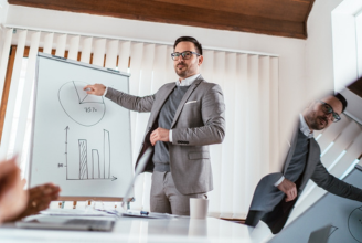 Consultant presenting marketing strategies and website development plans during a business meeting focused on SEO services in the UK.