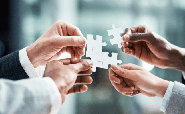 Hands putting together puzzle pieces, symbolizing the about section of the company
