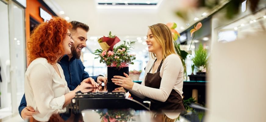 Florist shop staff providing personalized service to customers, demonstrating successful cost-effective retention strategies.