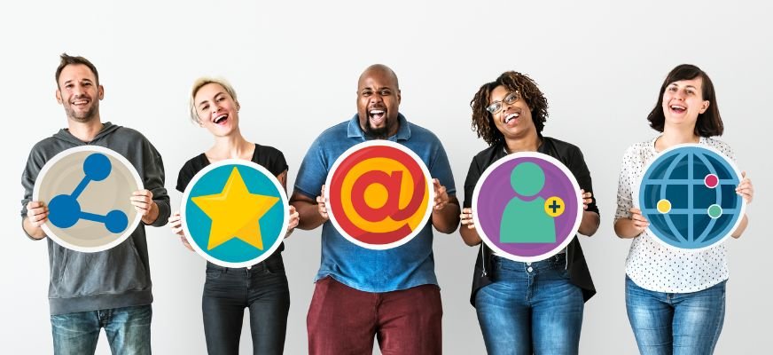 Group of people holding large social media icons, showcasing different platforms for social media marketing.